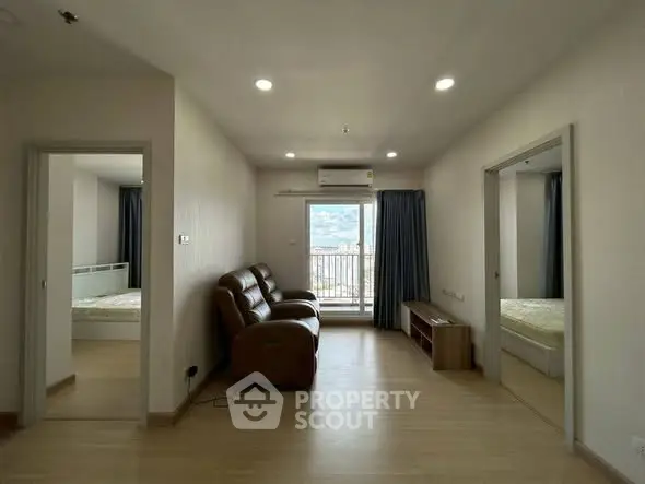 Spacious living room with balcony and natural light in modern apartment.