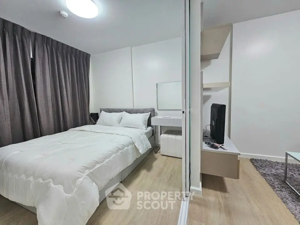 Modern bedroom with cozy bed, stylish decor, and sleek TV setup in a contemporary apartment.