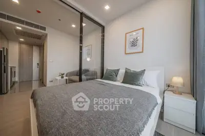 Modern bedroom with glass partition and cozy decor in a stylish apartment.