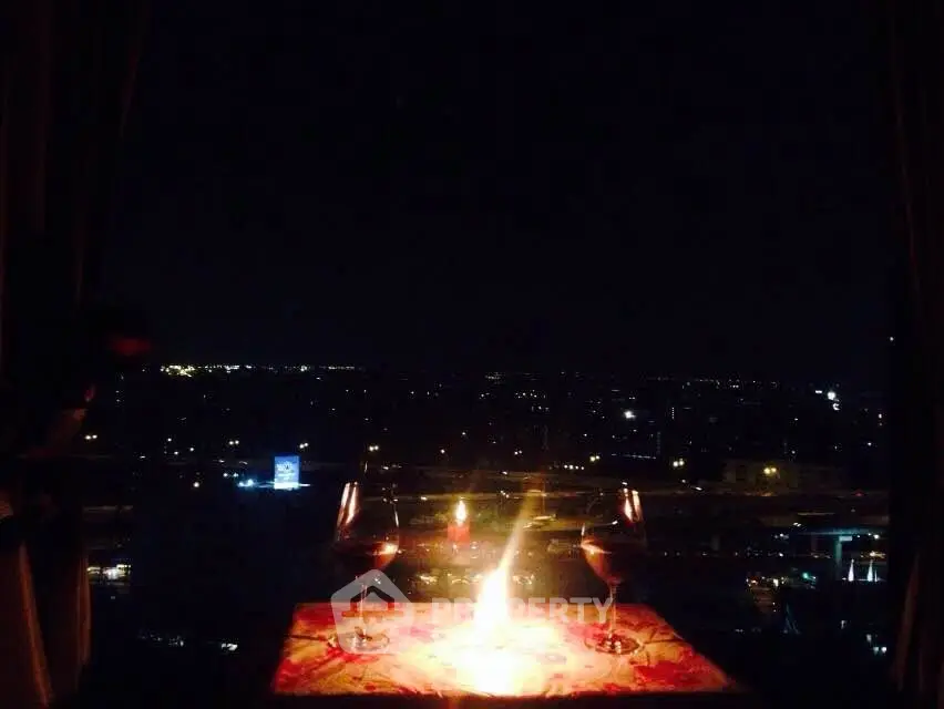 Romantic city view from a high-rise apartment with candlelit table setting.