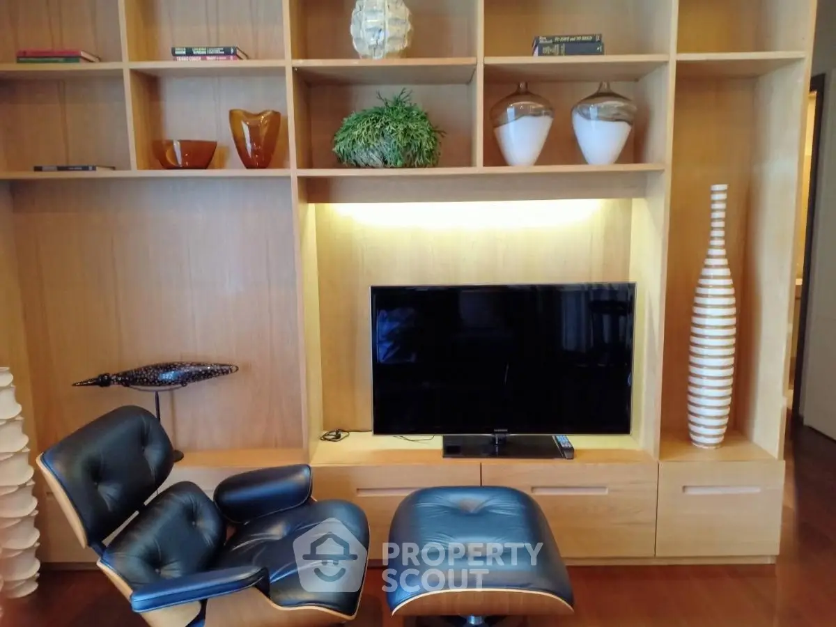 Stylish living room with modern chair and TV on wooden shelves