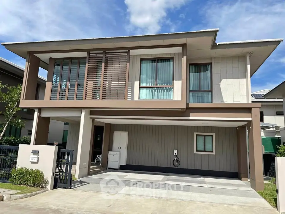 Modern two-story house with large windows and spacious driveway in a suburban neighborhood.