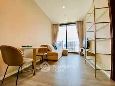 Modern living room with large window and city view, featuring cozy seating and stylish decor.