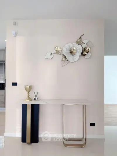 Elegant interior with modern console table and floral wall art in a stylish living space.