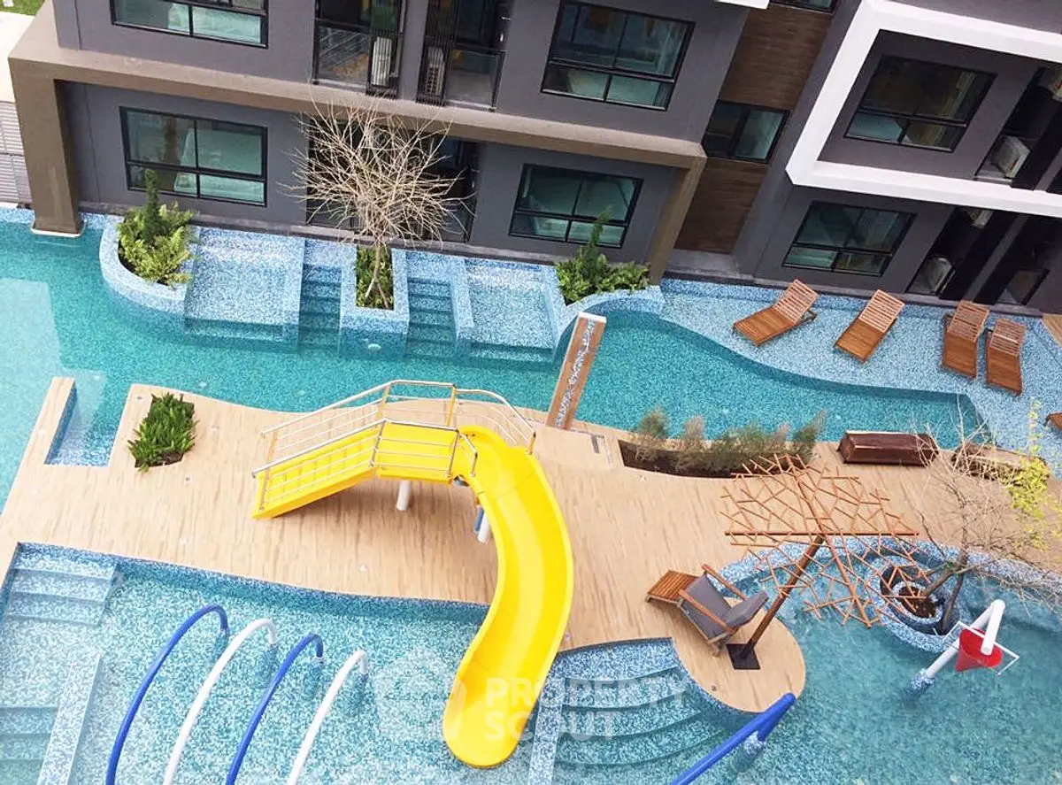 Luxurious apartment complex with stunning pool and slide, perfect for relaxation and leisure.