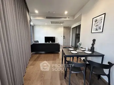 Modern living room with dining area, featuring sleek furniture and elegant decor in a contemporary apartment.