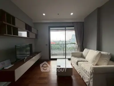 Modern living room with large window and city view, featuring sleek furniture and wooden flooring.