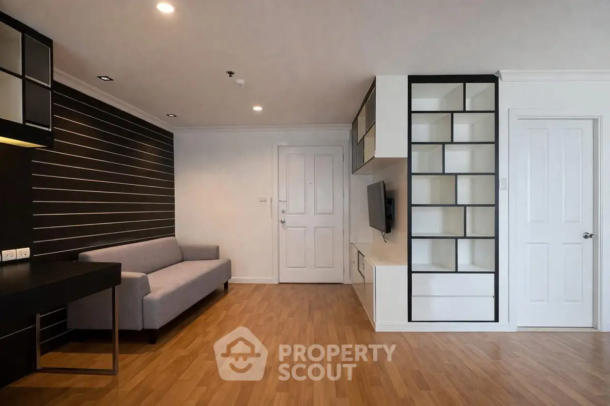 Modern living room with sleek built-in shelving and cozy sofa, perfect for urban living.