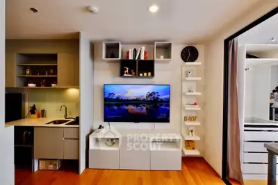 Modern living room with sleek TV setup and open kitchen layout