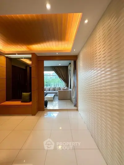 Elegant modern living room with stylish lighting and textured walls, offering a cozy and inviting atmosphere.