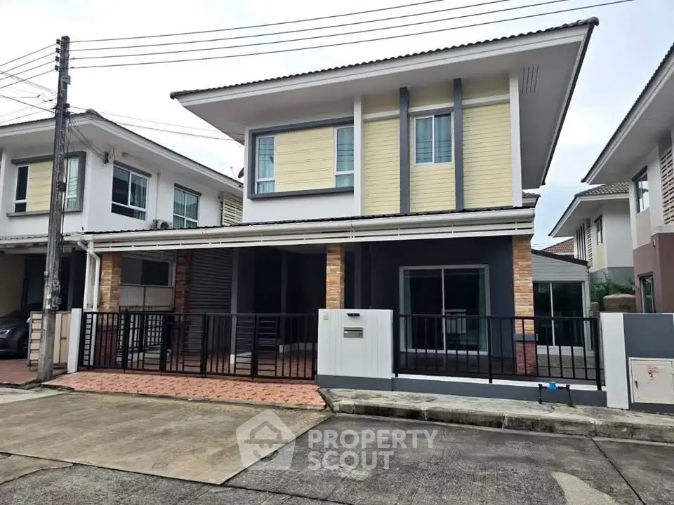 Modern two-story house with a sleek design and spacious driveway in a suburban neighborhood.