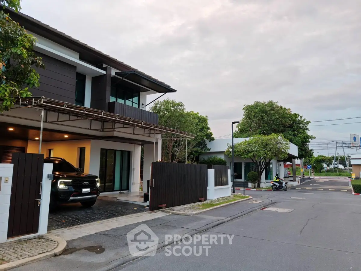 Modern two-story house with driveway and car in suburban neighborhood