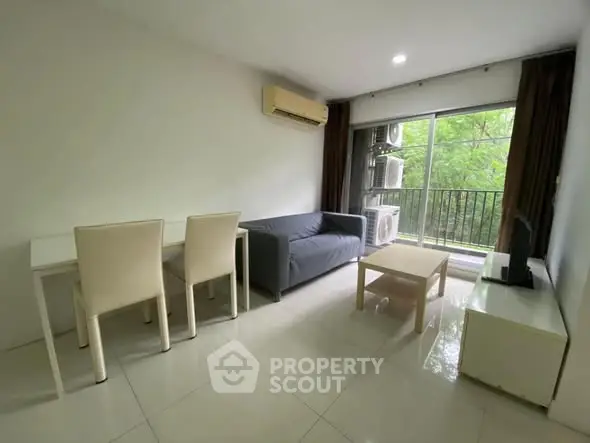 Modern living room with balcony and air conditioning, featuring sleek furniture and natural light.