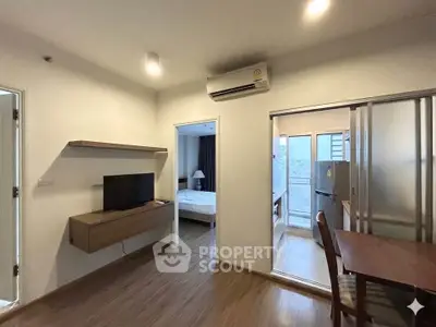 Modern apartment interior with open layout, featuring a cozy living area and a glimpse of the bedroom.