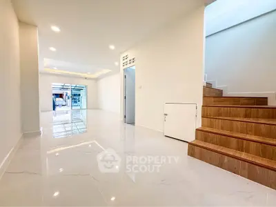 Spacious modern interior with glossy floors and wooden staircase