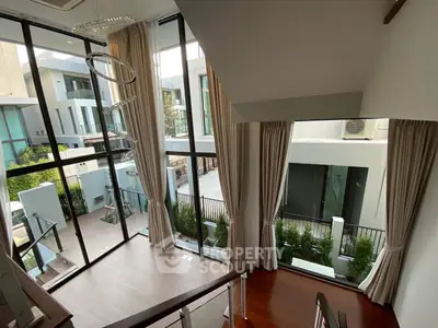 Luxurious modern living room with floor-to-ceiling windows and elegant curtains.