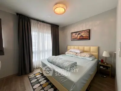 Cozy bedroom with elegant lighting and modern decor, featuring a large window with curtains and a stylish bed.
