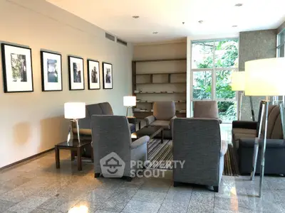 Elegant modern living room with stylish furniture and large windows offering lush garden views.