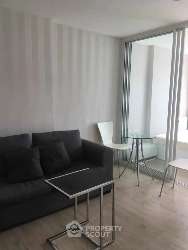 Modern living room with sleek furniture and glass partition in stylish apartment.