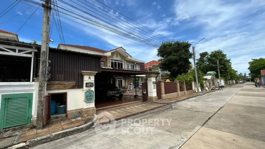 Charming suburban house with spacious driveway and lush greenery on a sunny day.