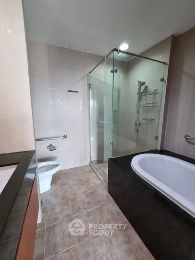 Modern bathroom with glass shower and bathtub in elegant real estate property.