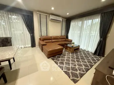 Spacious living room with modern leather sofa and large windows