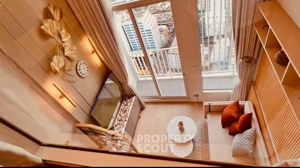 Modern living room with balcony view in high-rise apartment, featuring stylish decor and natural light.
