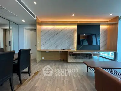 Modern living room with sleek wooden flooring and stylish wall paneling