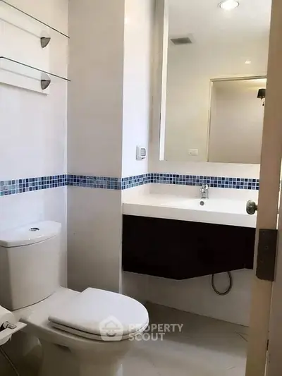 Modern bathroom with sleek fixtures and stylish blue tile accents.