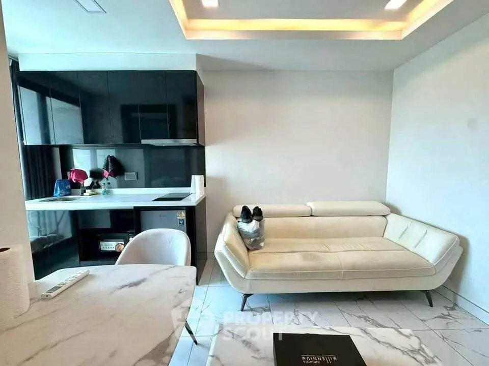 Modern living room with sleek kitchen, marble flooring, and stylish furniture in a contemporary apartment.