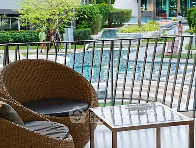 Luxurious balcony view overlooking a serene pool and lush garden, perfect for relaxation and leisure.