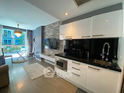 Modern open-layout kitchen and living area with pool view and elegant decor.