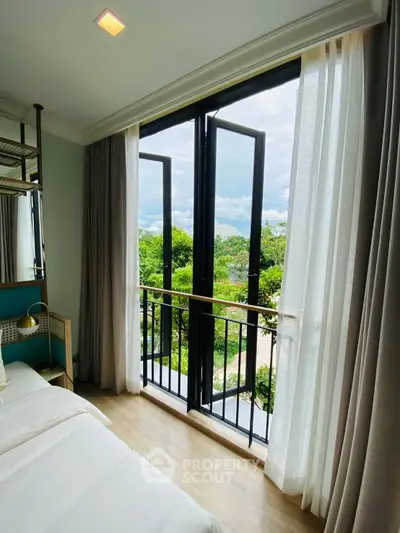 Bright bedroom with large windows and scenic view of lush greenery, perfect for relaxation.