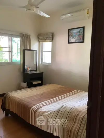Cozy bedroom with natural light, featuring a comfortable bed and elegant decor.