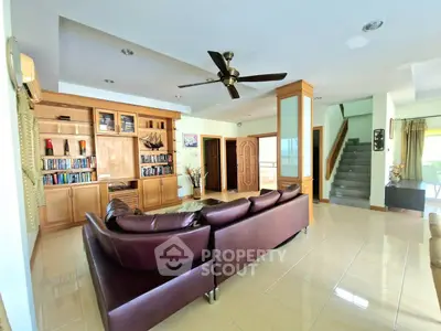 Spacious living room with leather sofa and built-in wooden shelves