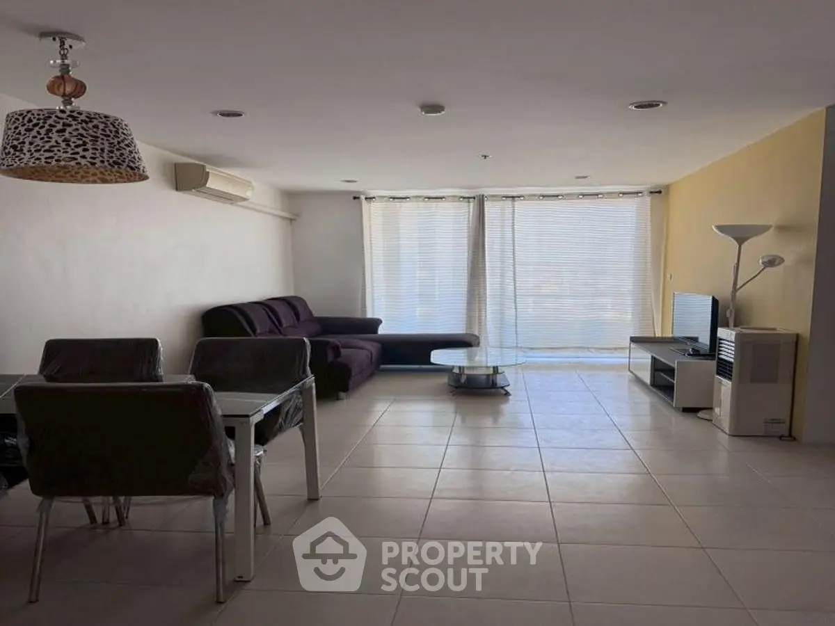 Spacious living room with modern furniture and large windows in a stylish apartment.