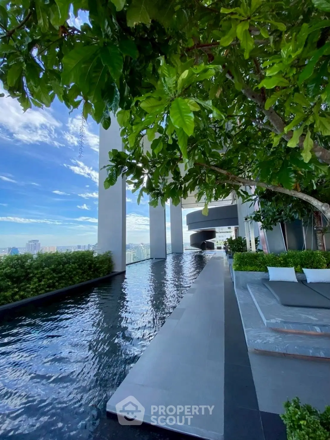 Luxurious rooftop pool with stunning city views and lush greenery, perfect for relaxation and leisure.