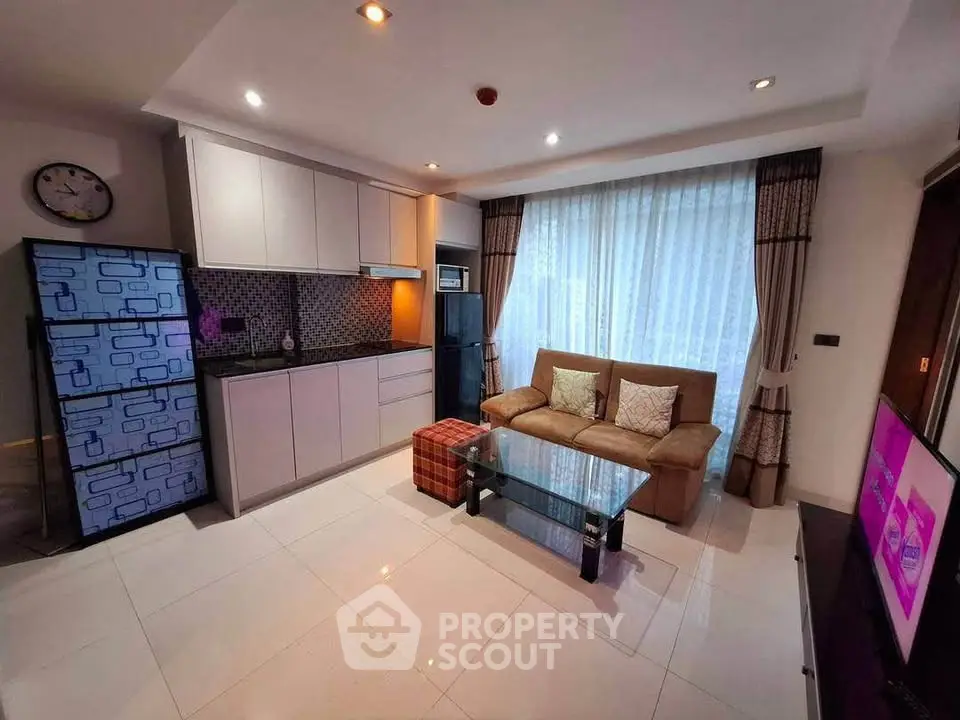 Modern living room with sleek kitchen, cozy sofa, and stylish decor in a contemporary apartment.