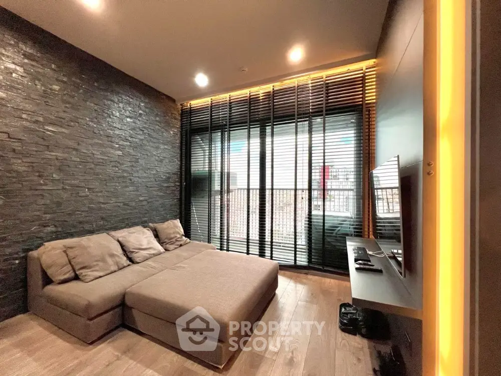 Modern living room with sleek design and large windows offering natural light and city views.