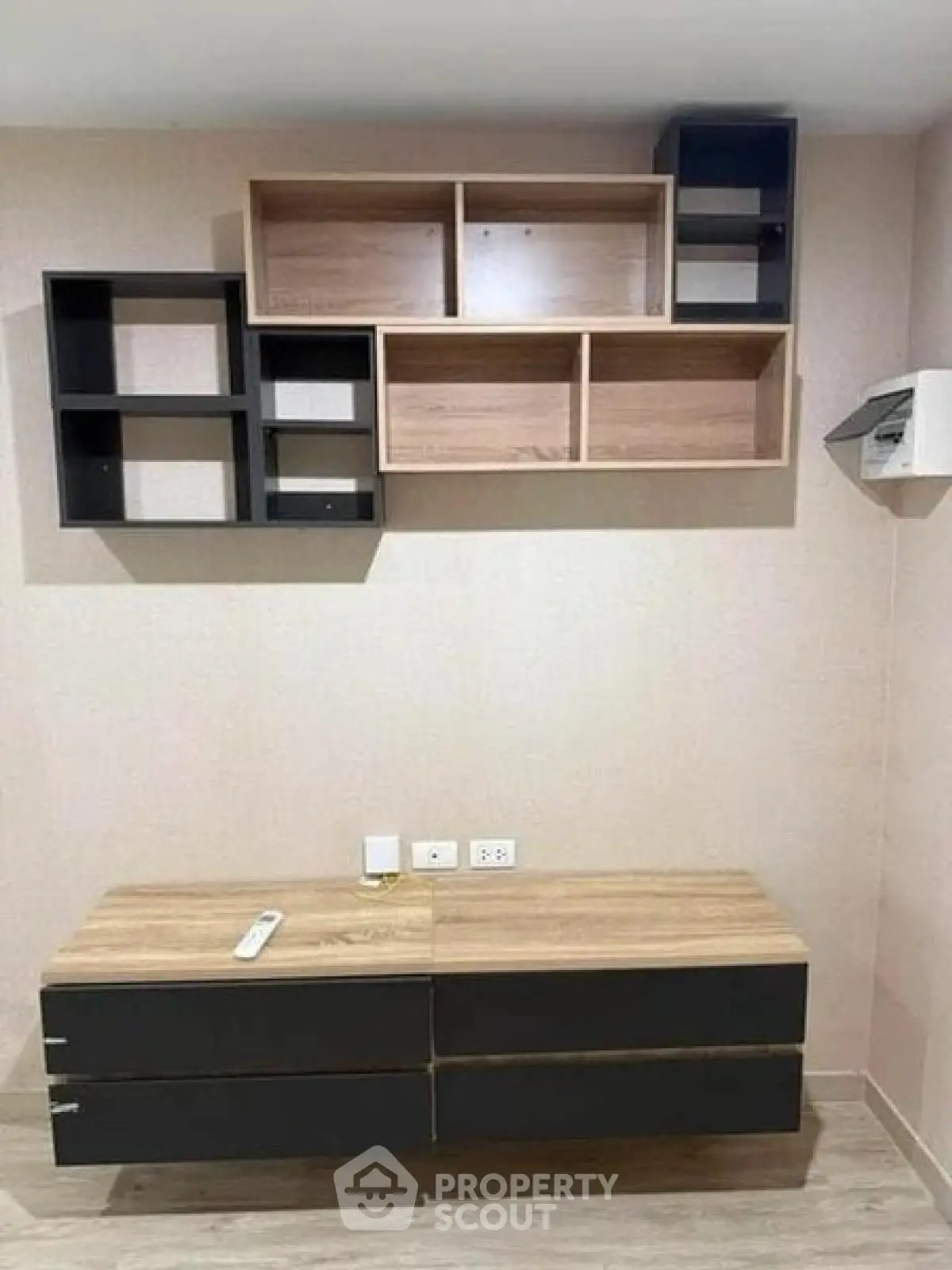 Modern minimalist living room with stylish wall-mounted shelves and sleek wooden cabinet.