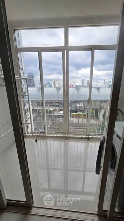Modern balcony with city view and laundry area in high-rise apartment