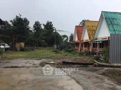 Charming row of colorful houses with lush greenery and spacious outdoor area.