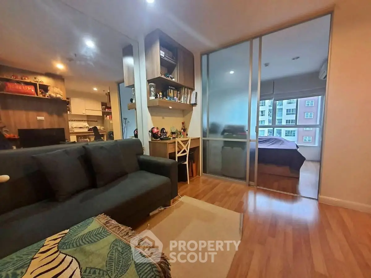 Modern apartment interior with cozy living room and bedroom view, featuring wooden flooring and stylish decor.