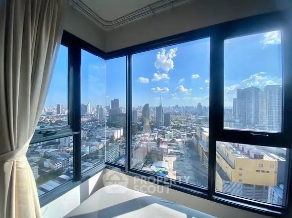 Stunning city view from high-rise apartment with large windows and natural light.