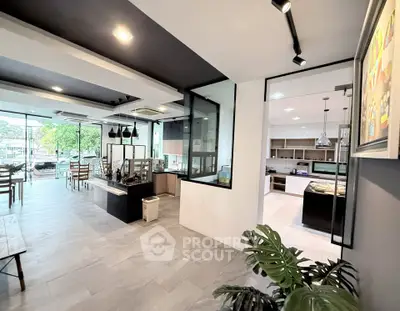 Modern open-plan kitchen and dining area with stylish decor and large windows.