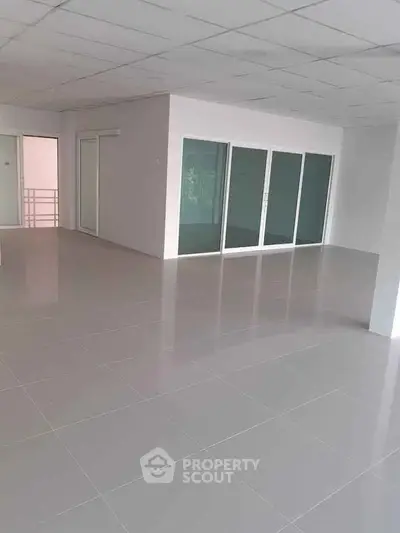Spacious modern interior with sleek tile flooring and glass doors, perfect for versatile office or living space.