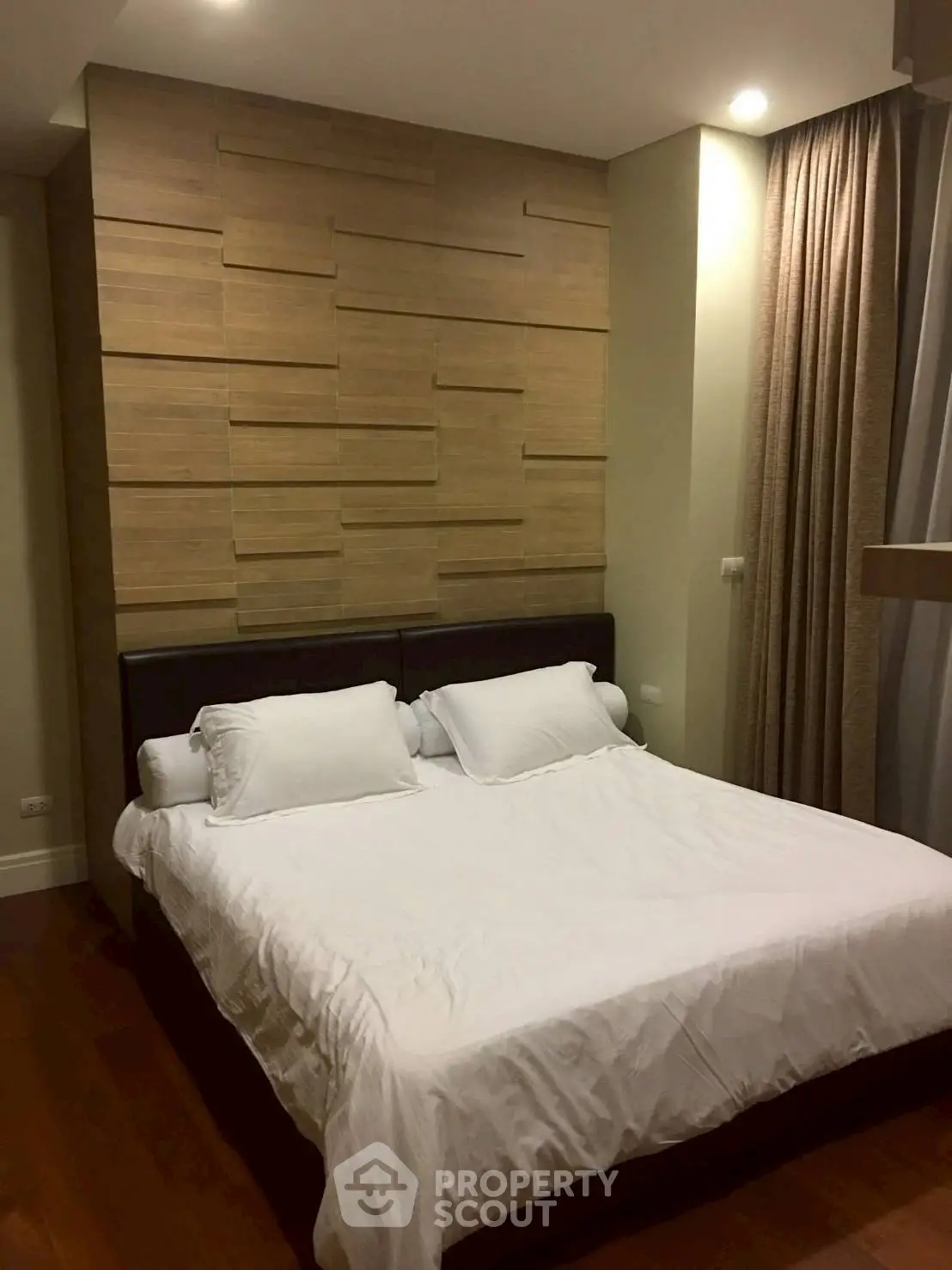 Elegant bedroom with modern wood paneling and cozy lighting