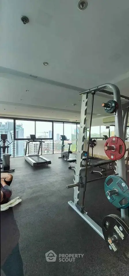 Spacious modern gym with city view in luxury apartment building