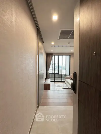 Modern apartment entrance leading to a cozy living room with city view.