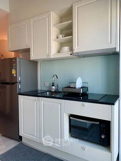 Modern compact kitchen with sleek cabinetry and built-in appliances, perfect for urban living.